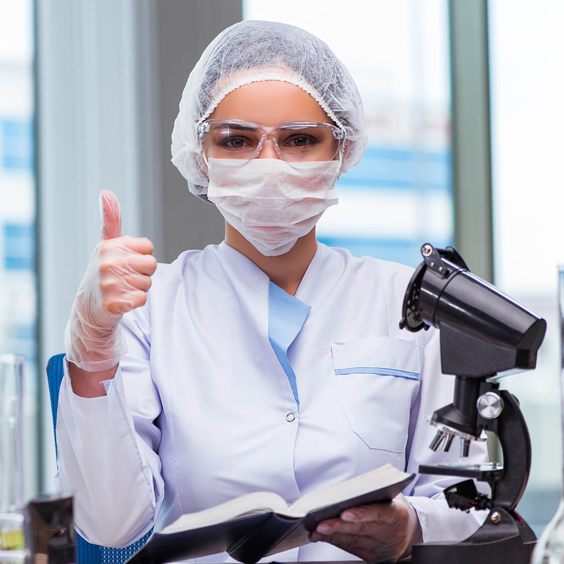 Laboratory professional reviewing samples near a microscope